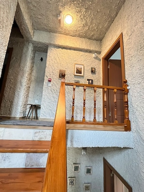 A wooden staircase with a handrail leading to a landing. - Marsel Rooms (İzmir)