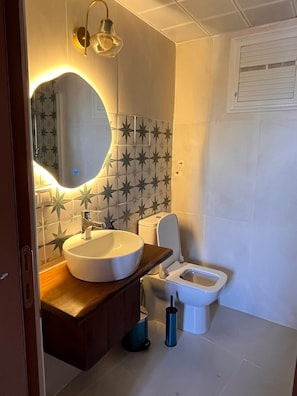 A bathroom with a round sink, a toilet, and a bidet. - Marsel Rooms (İzmir)