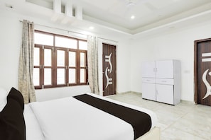Une chambre à coucher avec un lit, une armoire et une fenêtre avec des rideaux.