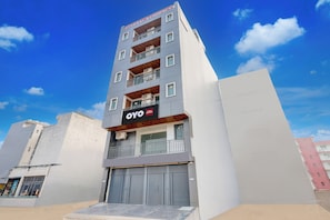 A multi-story building with balconies, an air conditioning unit, and a sign for 'ETERNAL RESIDENCY'. - Hotel O by OYO ETERNAL RESIDENCY (Gurugram)