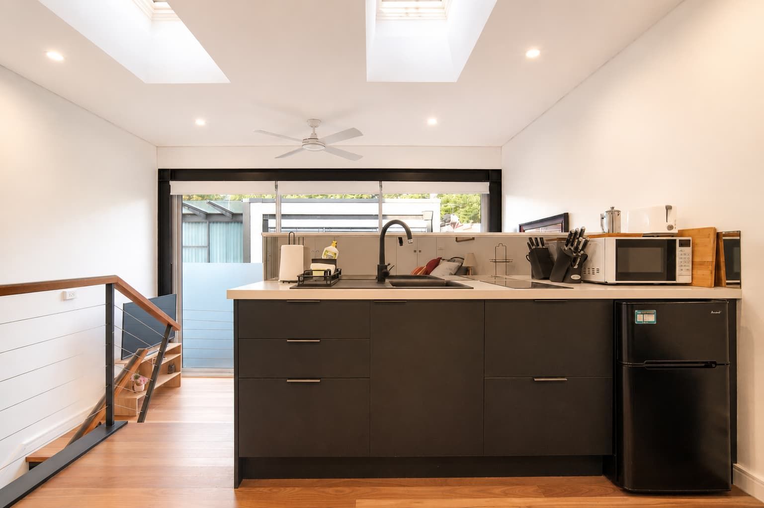 A modern kitchen with a central island, a built-in oven, and a refrigerator.