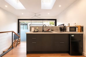 A modern kitchen with a central island, a built-in oven, and a refrigerator. - 6min to Darling Harbour | 3min to The Star | 100M (Pyrmont)