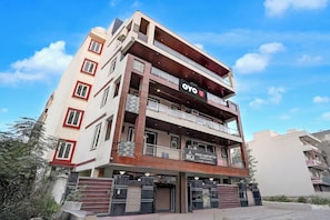 A multi-story hotel with a modern facade, balconies, and signage for 'OYO Hotel Urban Sky' and 'HOTEL COMFORT INN.' - Hotel O Urban Sky (Gurugram)