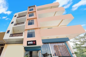 Un edificio a più piani con un cartello che indica 'Safe & Sure Residency'.