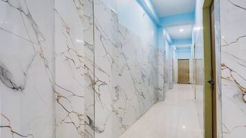 Un corridoio con pareti in marmo bianco e soffitto blu.