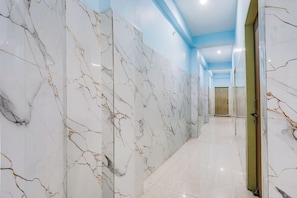 Un corridoio con pareti in marmo bianco e soffitto blu.