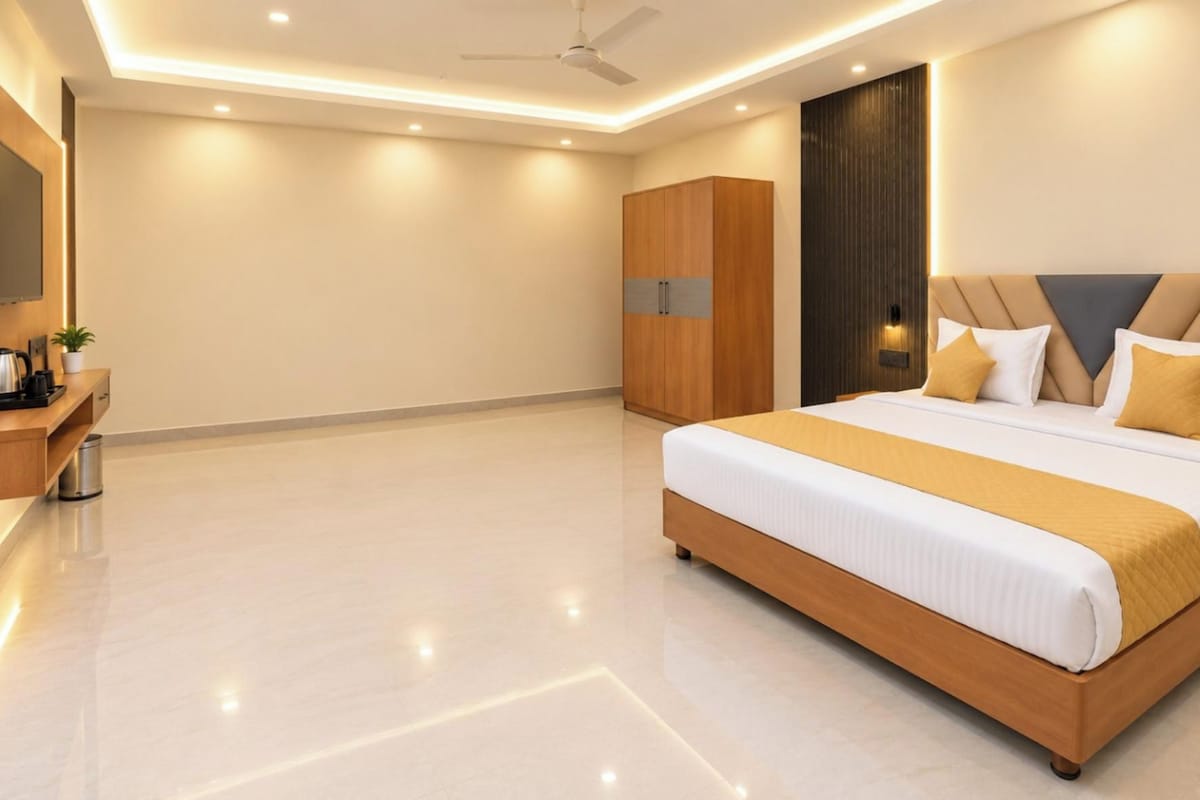 A modern bedroom with a large bed, a wardrobe, a bedside table, and a TV.
