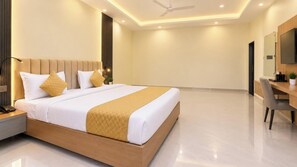 A modern hotel room with a large bed, bedside tables, a desk, and a chair. - Hotel Shyamagiri (Ranopali)