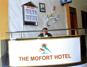 Un mostrador de recepción en el Hotel Mofort con un cartel que dice 'KEY BOX'.