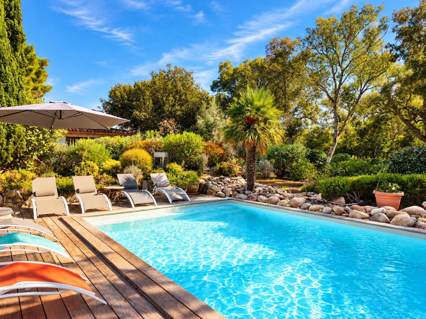 Una piscina con sillas de descanso y una terraza de madera.