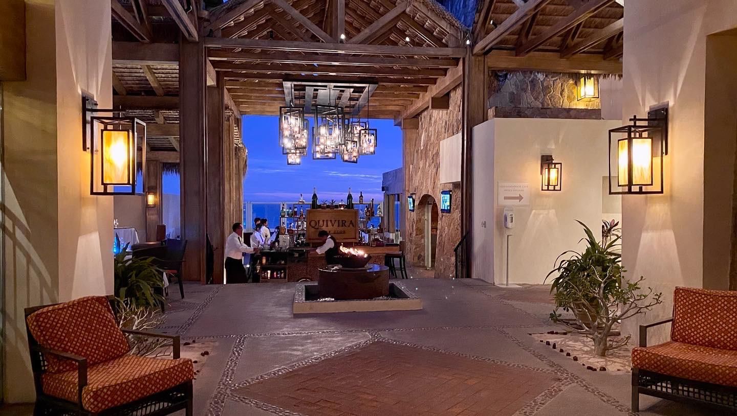 Eine Lobby mit Barbereich, Sitzgelegenheiten und einer Steinwand.