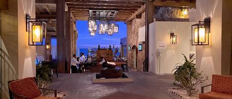 A lobby with a bar area, seating, and a stone wall.