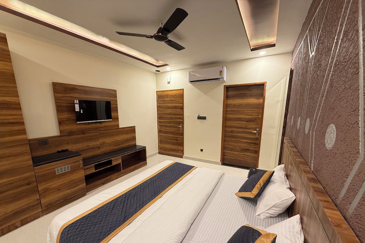 Een moderne slaapkamer met een bed, een televisie, een kledingkast en een plafondventilator.