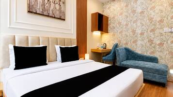 A hotel room with a large bed, a desk, a chair, and a decorative wall.