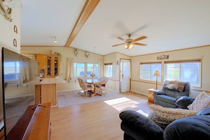 A spacious living area with a dining table, a sofa, and a ceiling fan. - Montana Mountain Escape! Views, Trails & Toys (Dupuyer)