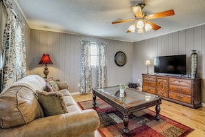 A living room with a sofa, coffee table, TV, and wooden cabinet.
