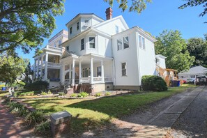 A large, two-story white house with a porch, multiple windows, and a brick chimney. - Walk to Olde Towne & River! Charming Escape (Portsmouth)