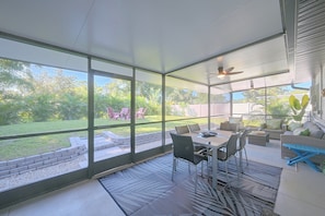 A covered patio area with a table and chairs, a ceiling fan, and a view of the backyard. - Paradise Del Sol by Gulf Beaches: Endless Summer! (Nokomis)
