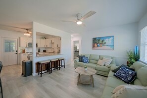A modern kitchen with a dining area, a living room with a sofa and a coffee table, and a ceiling fan. - Paradise Del Sol by Gulf Beaches: Endless Summer! (Nokomis)