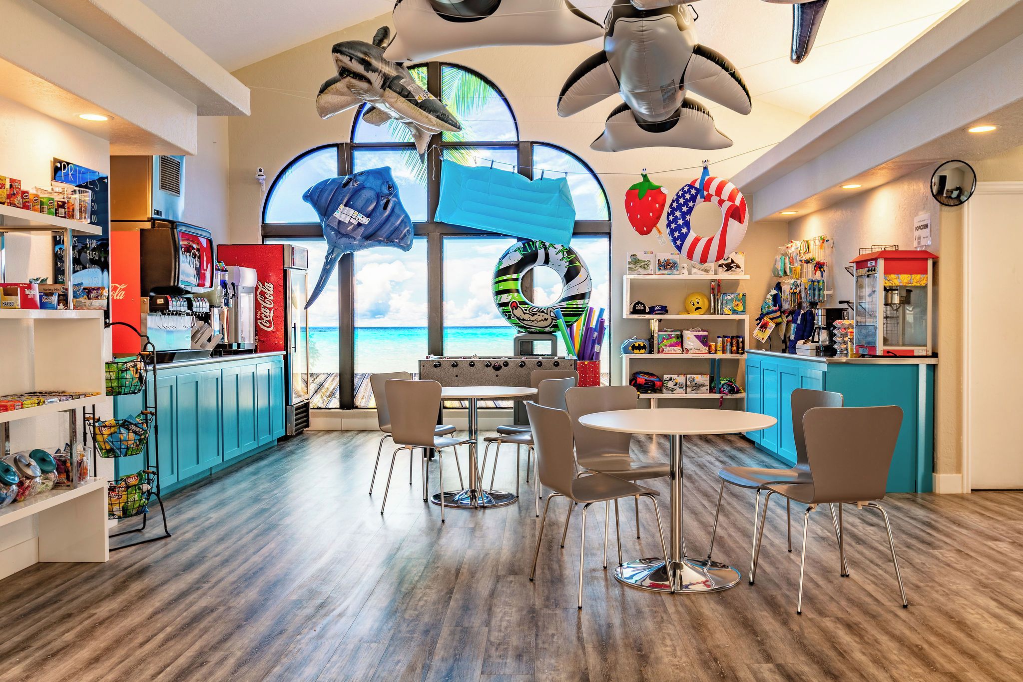 A beach-themed restaurant with a view of the ocean, seating arrangements, and various food and drink options.