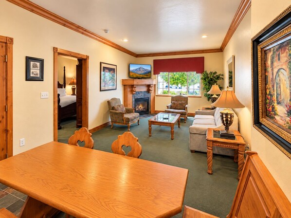 A cozy living room with a fireplace, comfortable seating, and a dining area.