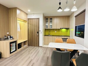 Una cocina moderna con armarios de madera, horno empotrado y comedor con mesa y sillas.