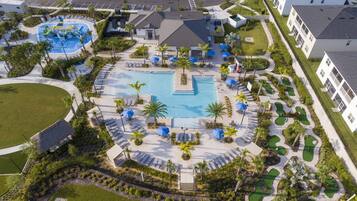 Un complejo turístico con piscina central, varias zonas de descanso y un campo de golf.