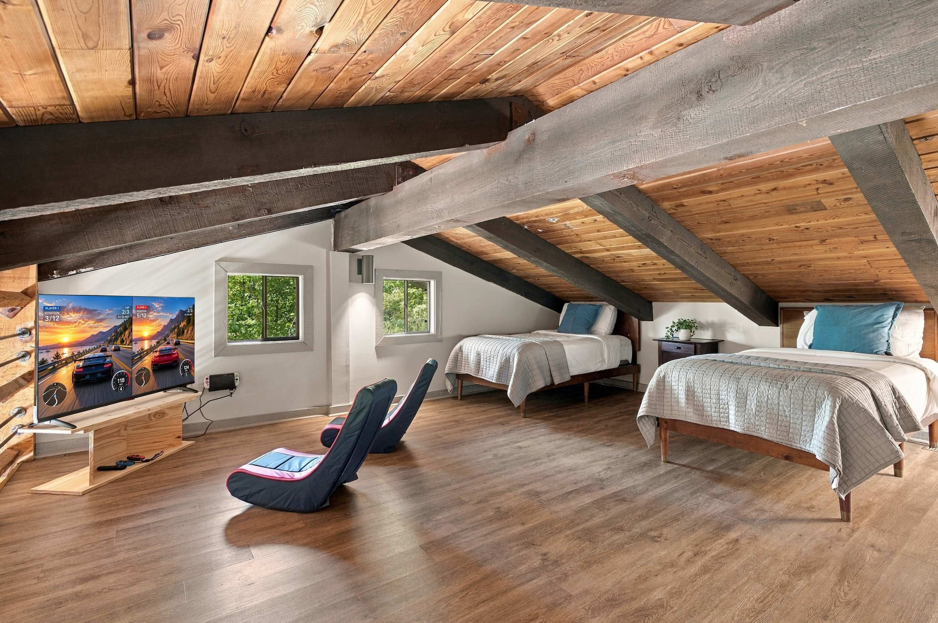 A cozy attic bedroom with a sloped ceiling, wooden beams, a bed, two bedside tables, a chair, and a large window.