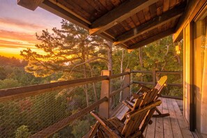 A wooden deck with a view of a forest and a sunset. - 2BR Top-floor Condo With Views Resort Amenities (Sevierville)