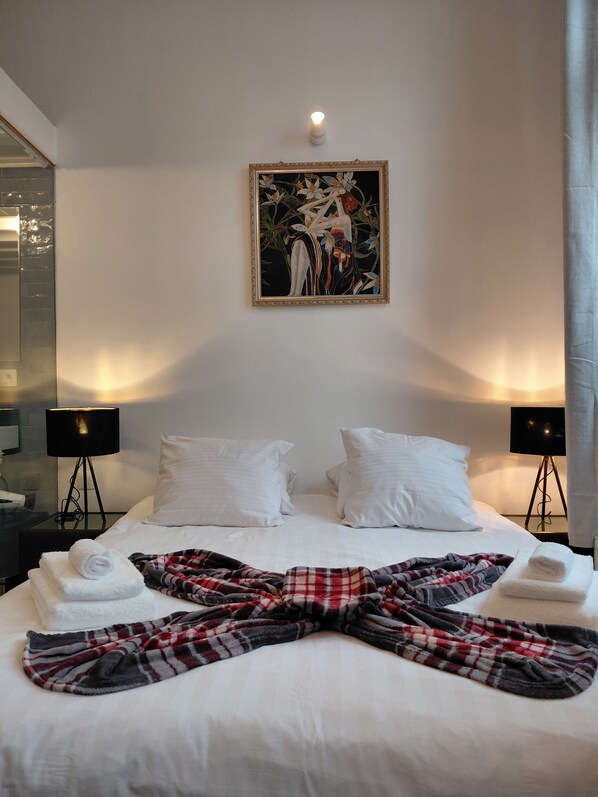 A hotel room with a bed, two bedside lamps, a painting on the wall, and a large mirror. - New Listing (Antwerpen)