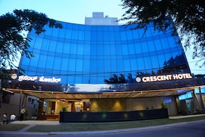 A hotel with a modern glass facade, a prominent entrance, and signage indicating the hotel name. - Crescent Hotel (Mysuru)