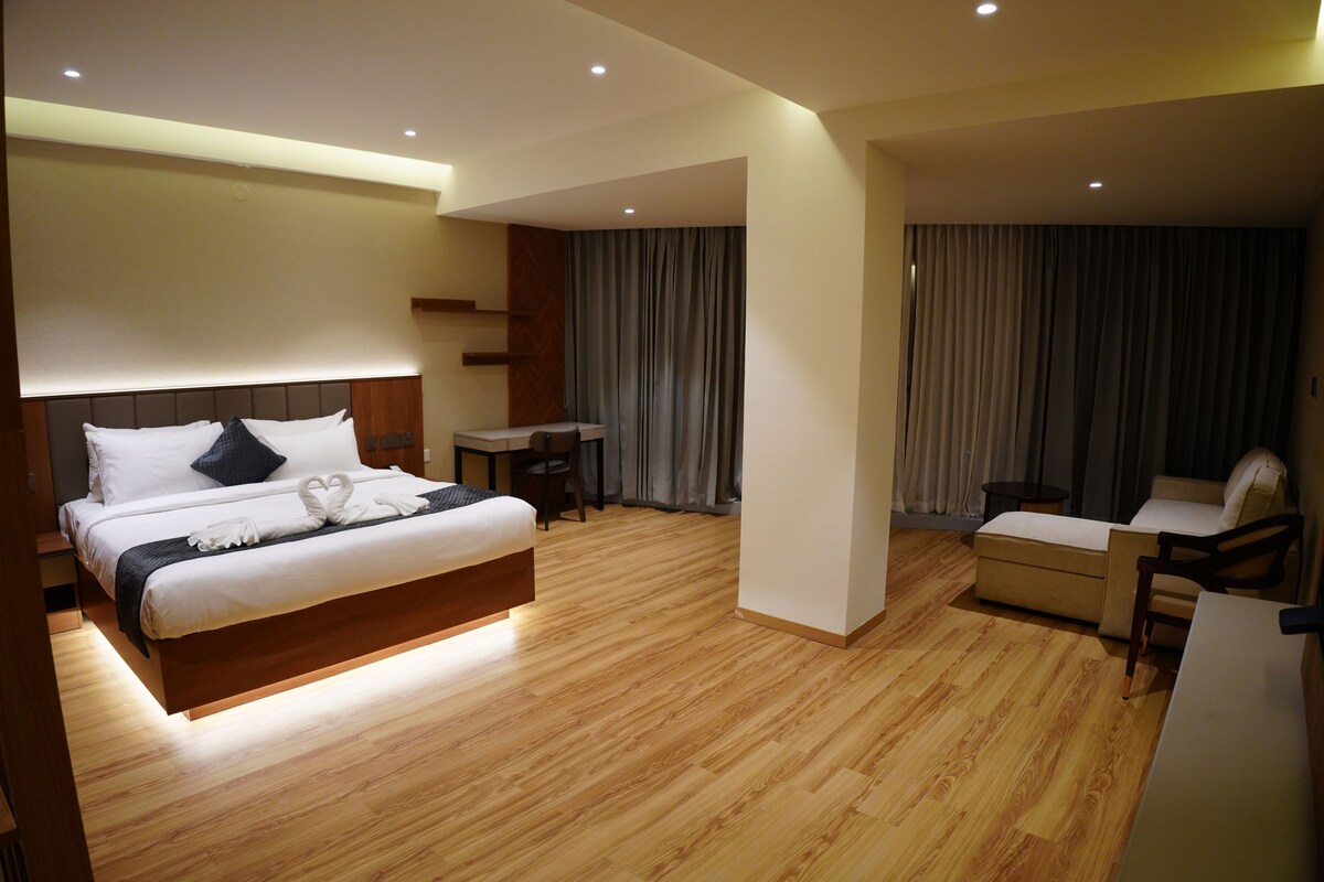 A modern hotel room with a large bed, a desk, and a chair.