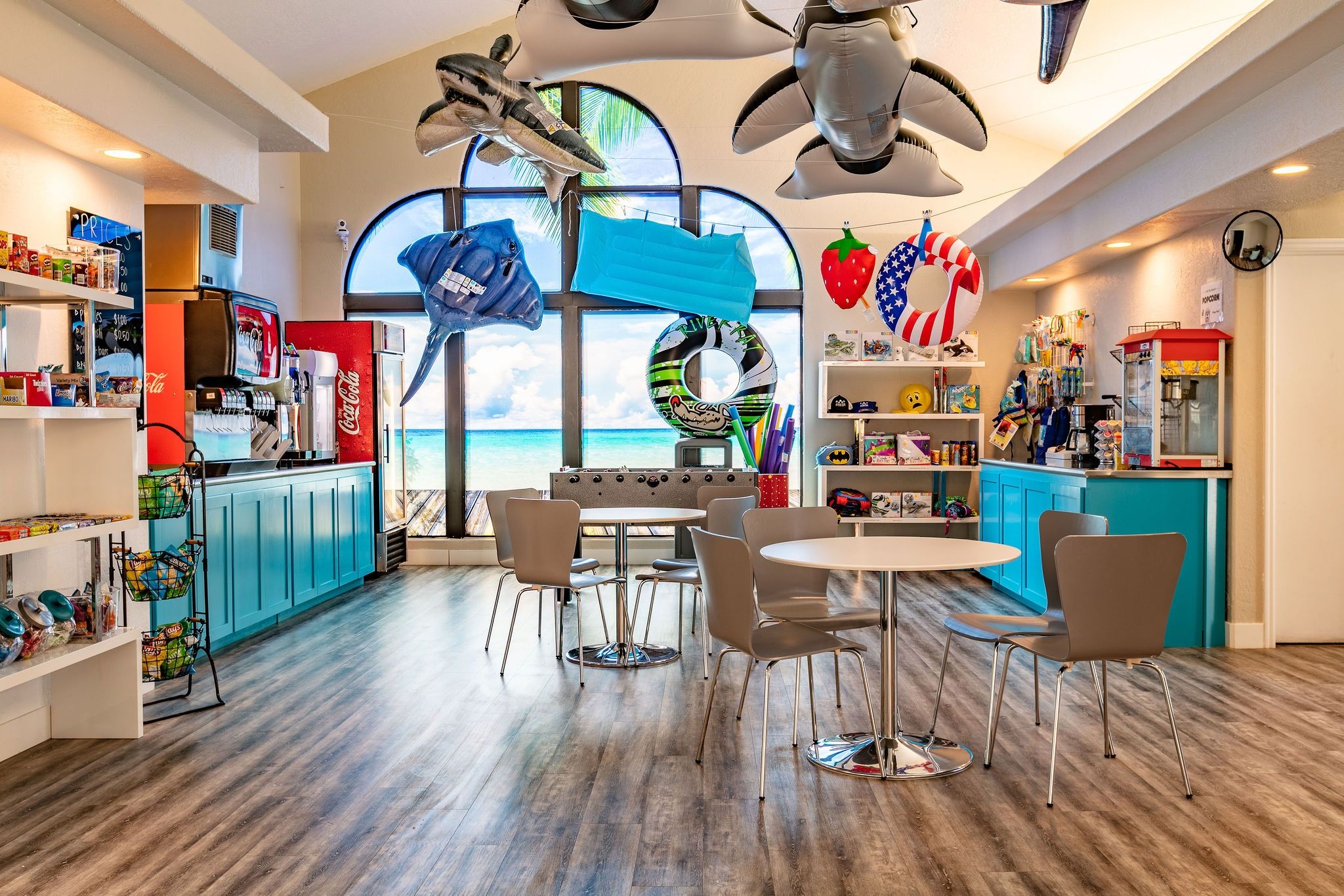 A beach-themed restaurant with a view of the ocean, seating arrangements, and various food and drink options.