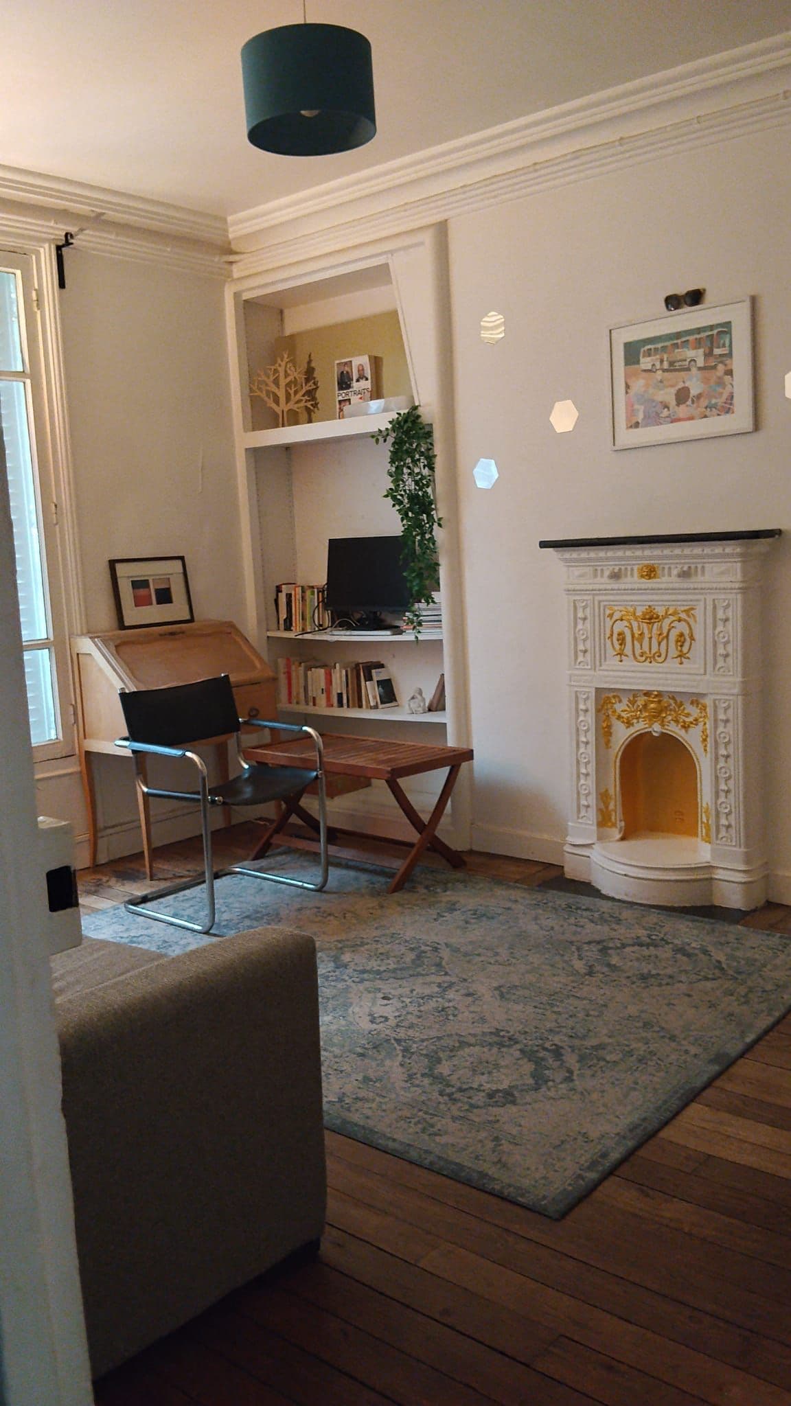 A room with a fireplace, a bookshelf, a television, and a chair.
