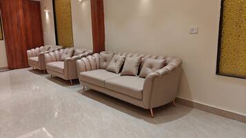 Una sala moderna con un sofá seccional color beige, un sillón a juego y una mesita de centro.