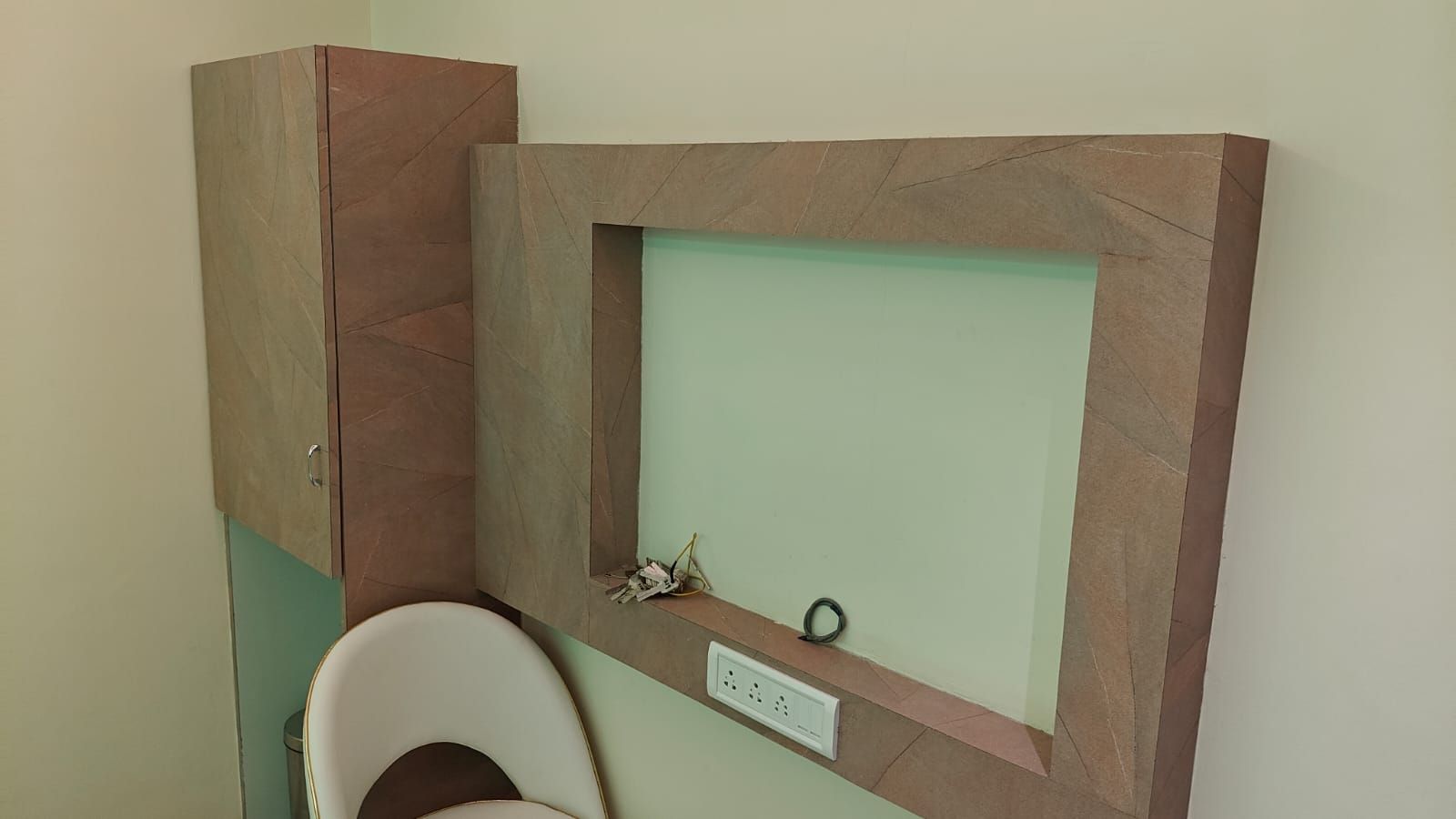 Un baño con inodoro, un armario y un espejo instalado en la pared.