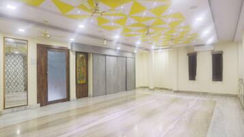 A spacious room with a marble floor, a wooden door, and a patterned wall.