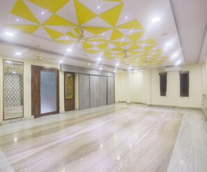 A spacious room with a marble floor, a wooden door, and a patterned wall. - Super Deluxe Room Hotel Roopali (Jabalpur)
