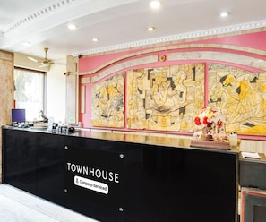 A reception desk with a 'Townhouse' sign, a decorative wall with relief art, and a ceiling with recessed lighting. - Super Deluxe Room Hotel Roopali (Jabalpur)