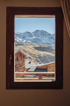 A wooden cabin with a view of snow-covered mountains through a window. - Balcons 647 (Les Belleville)
