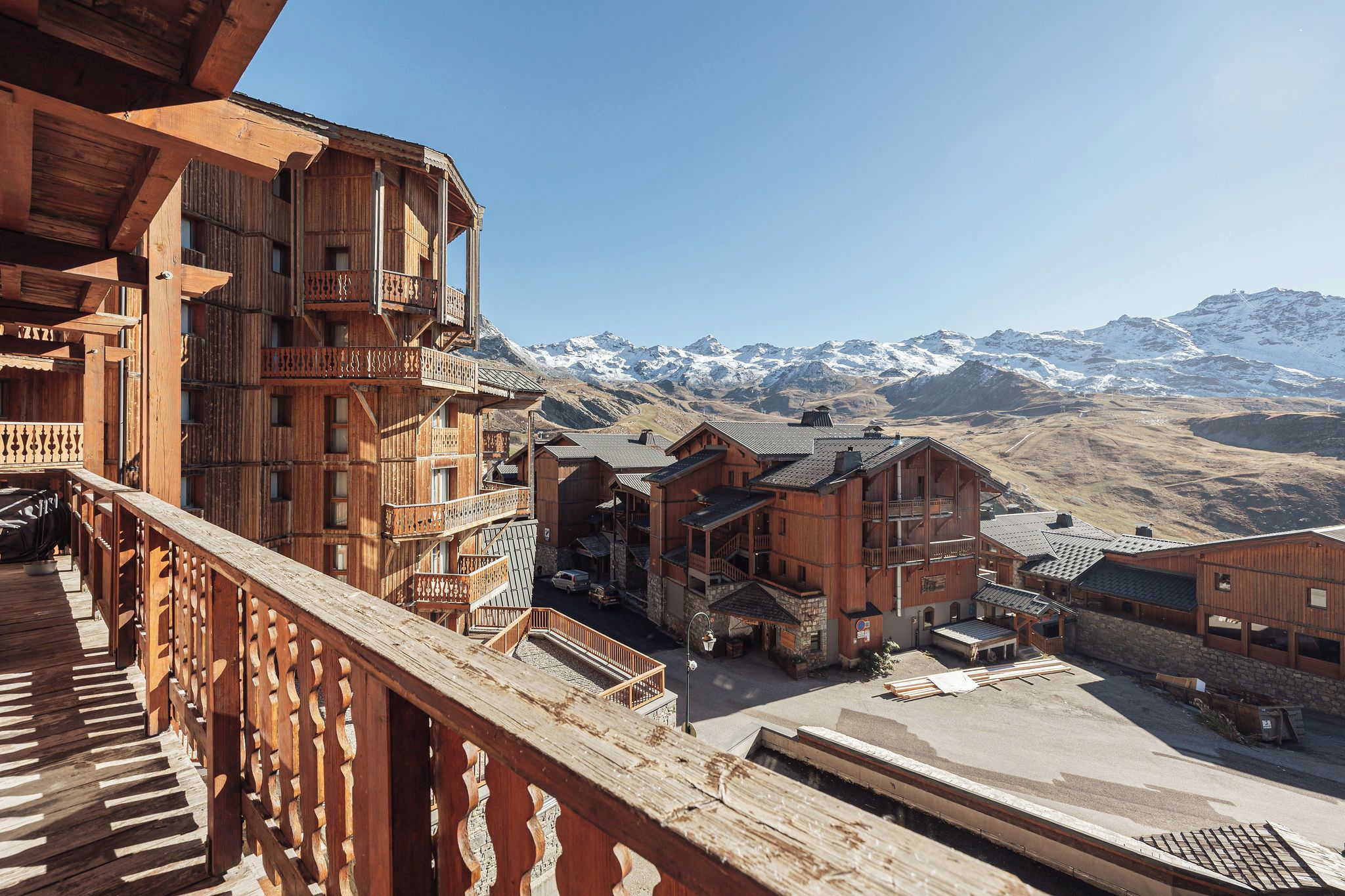 A wooden building with balconies and a view of snow-capped mountains.
