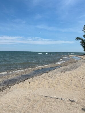 A beach with a pebbly shore and calm sea.