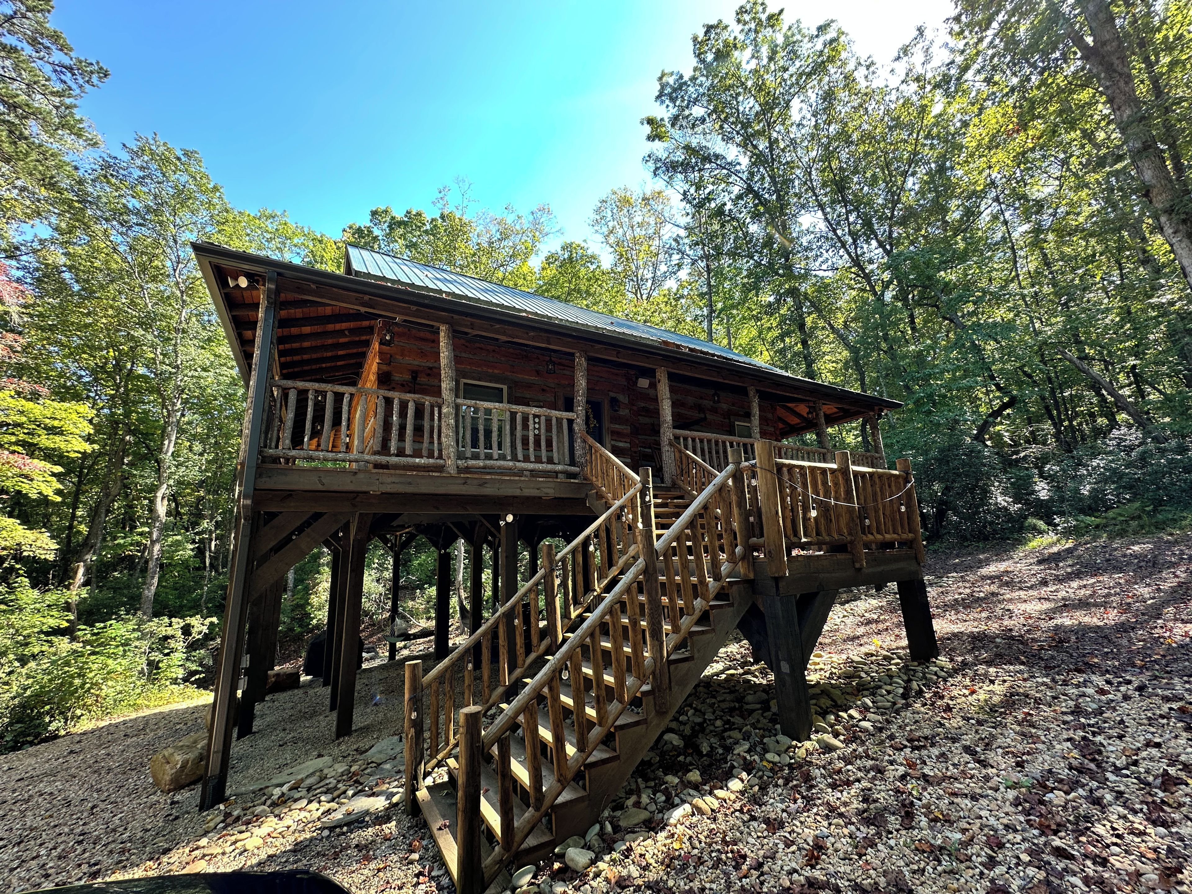 A wooden cabin with a balcony and a staircase.