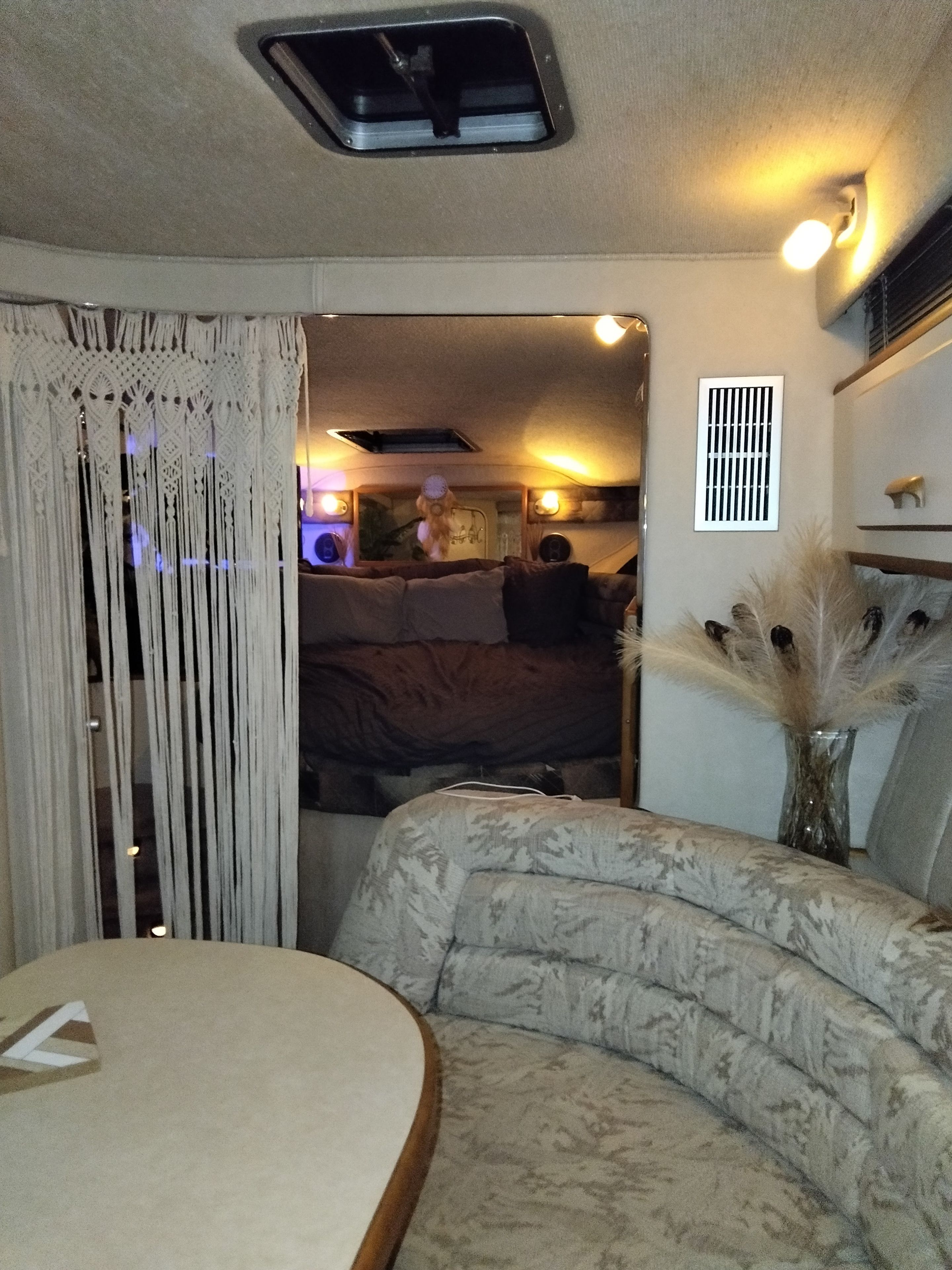 Un interior acogedor con un sofá estampado, una mesita y una cortina decorativa.
