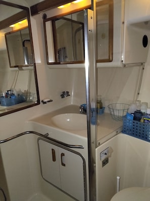 Un baño con un lavabo blanco, un espejo y una cabina de ducha.