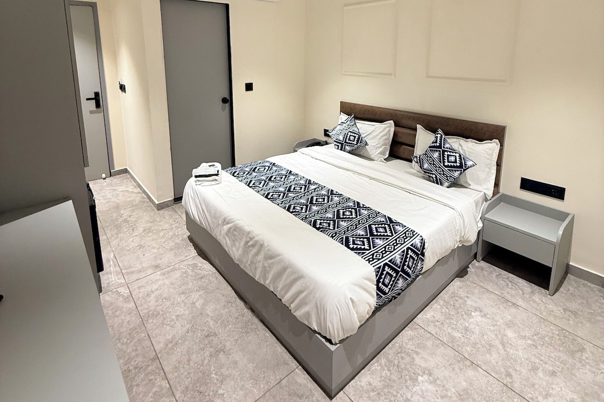 A modern bedroom with a bed, bedside tables, a ceiling fan, and an air conditioning unit.