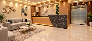 A modern hotel lobby with a reception desk, a sofa, a coffee table, and a refrigerator. - GATEWAY CONTINENTAL EXPRESS (Kolkata)