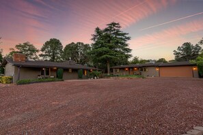 A two-story building with a gravel driveway and a large tree in front. - Sedona Red Rock Retreat for 8 | 2 Homes, 4BR, Sunroom Dining, Game Room, Fire Pit & Private Patios (Sedona)
