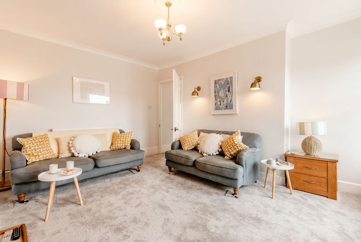 A living room with two grey sofas, a coffee table, a side table, and a lamp.