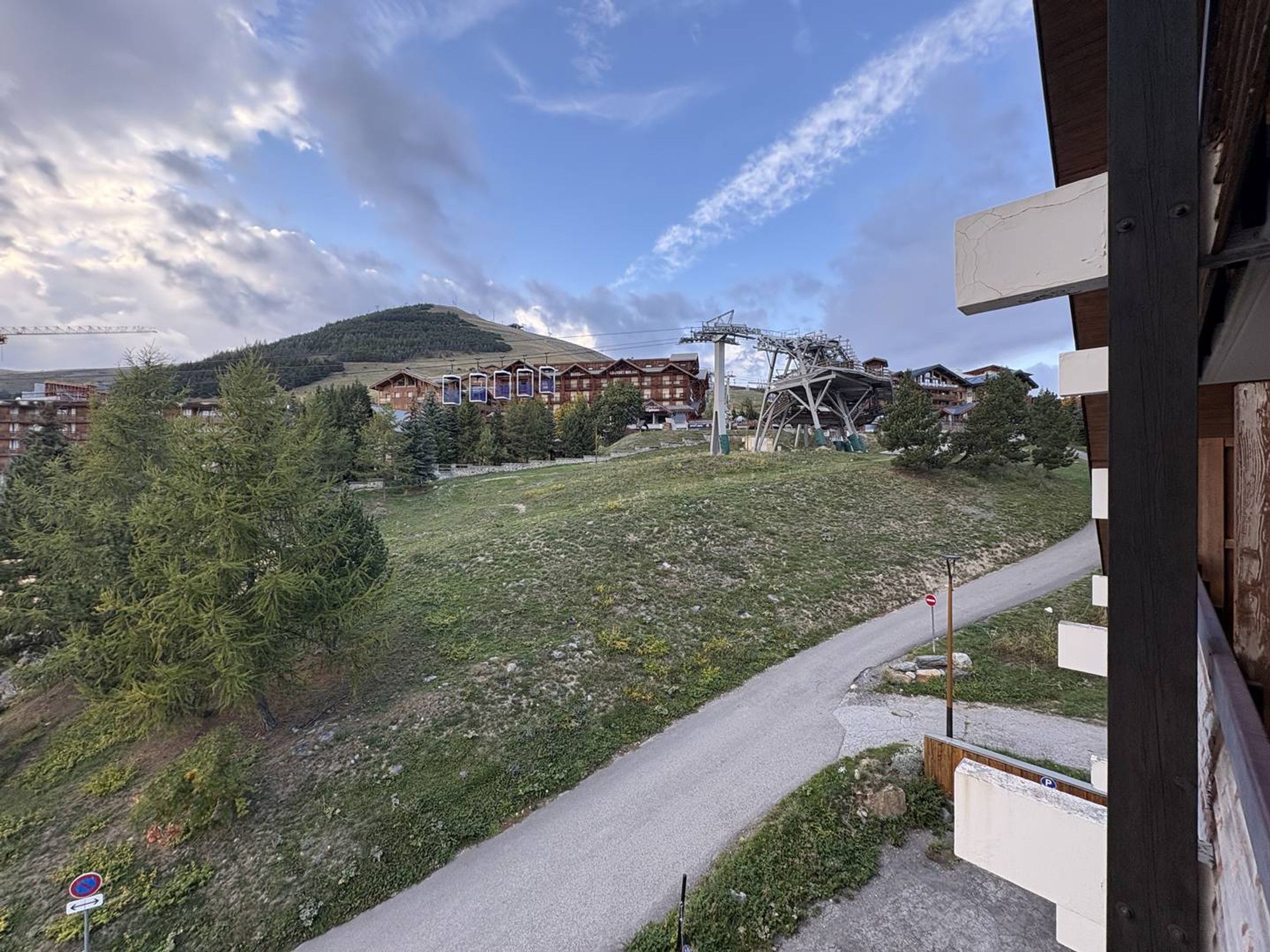 A ski resort with a ski lift, buildings, and a mountain in the background.